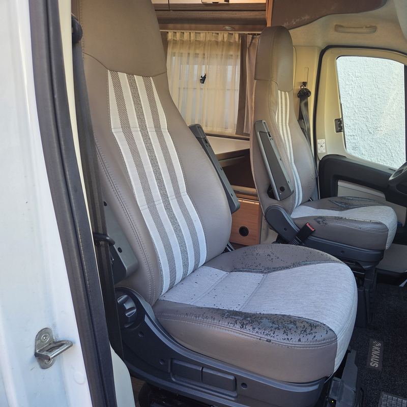 Wohnmobil-Fahrersitz vorher mit abgeplatztem Kunstleder und Streifenstoff